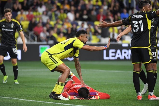 Mar 30, 2024; Nashville, Tennessee, USA; Nashville SC midfielder Anibal Godoy (20) checks on Columbus Crew goalkeeper Patrick Schulte (28) after he was injured in the first half at Geodis Park. Mandatory Credit: Christopher Hanewinckel-USA TODAY Sports