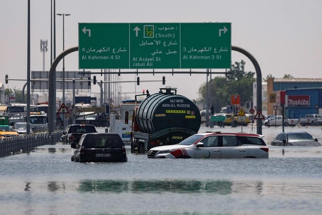 Cars are stranded in flood water on a blocked highway Friday following heavy rainfall, in Dubai, United Arab Emirates.