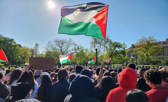 Protestors calling for Ohio State University to divest investment in businesses linked to Israel waved a Palestinian flag at a demonstration outside the Ohio Union on Thursday