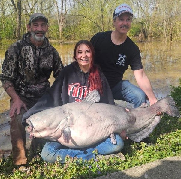Jaylynn Parker, center, landed a 101-pound blue catfish on the Ohio River with the help of her dad, Chuck Parker, left, and family friend Jeff Sams.