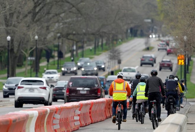 A group of cyclists travels along a quick-build, two-way bike lane separated from motor vehicles along East Broad Street as the Columbus Department of Public Service tested the lane erected between Franklin Park West and the entrance to Wolfe Park.