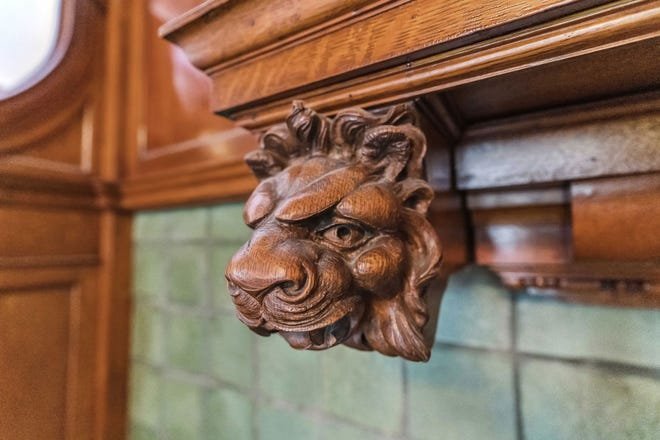 A home built for and Urbana lumber baron includes carved lion's heads over the fireplace in the foyer.