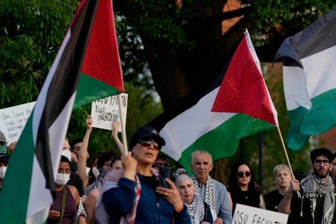 Protestors gather and wave Palestinian flags during a Wednesday protest on Ohio State University's South Green during a demonstrations where hundreds gathered in support of Palestine.
